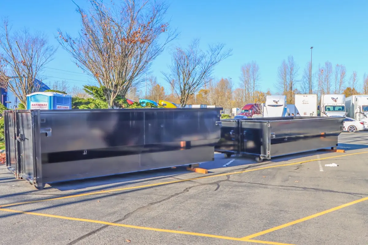 Professional dumpster rental service with roll-off container on residential driveway in Caribou